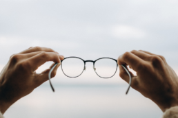 Holding up a pair of glasses representing turning vision into value