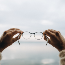 Holding up a pair of glasses representing turning vision into value